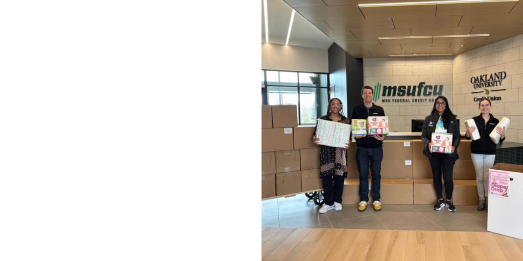 Credit Union employees hold donations for the MiSide Diaper Drive.