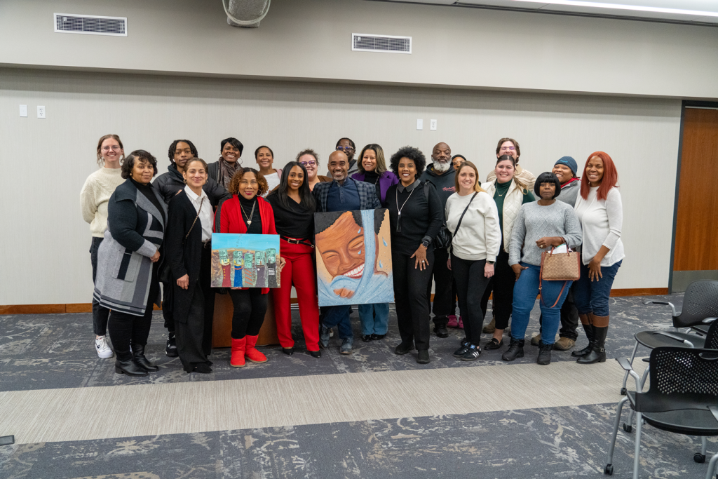 A group of individuals stand posing for a photo at The Culture of Finances graduation.